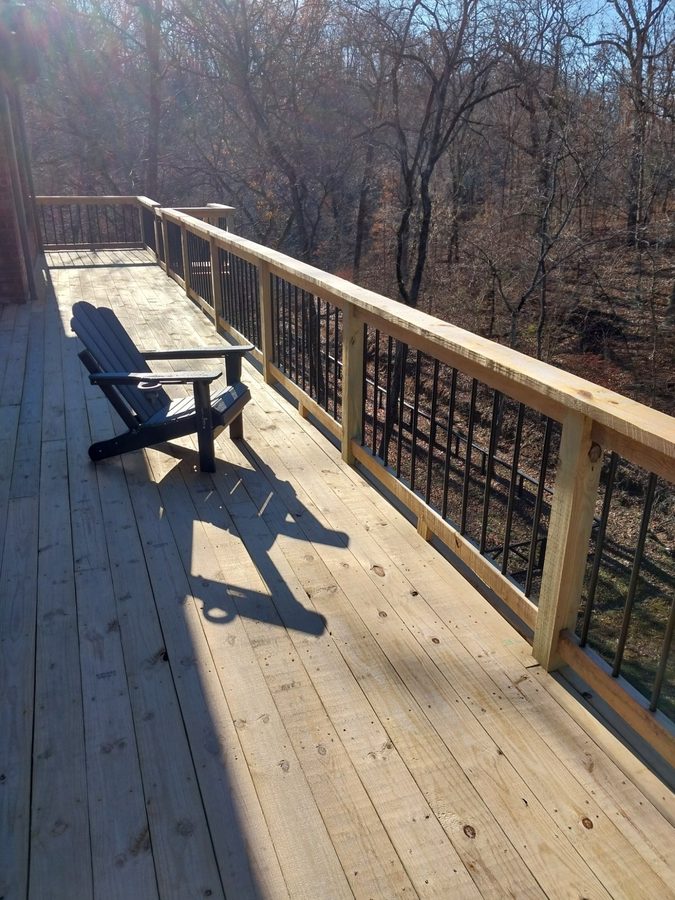 Elevated wood deck with metal balusters overlooking Ozark woods, Northwest Arkansas