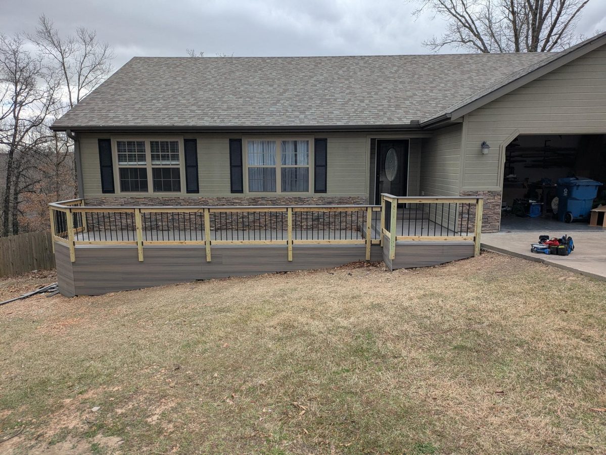 Composite deck with fascia boards and black metal railing on ranch home, Northwest Arkansas