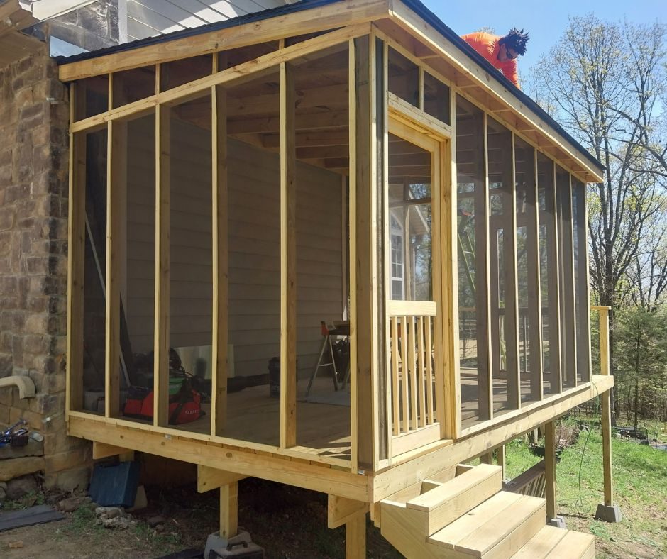 Screened porch under construction next to stone home, Northwest Arkansas